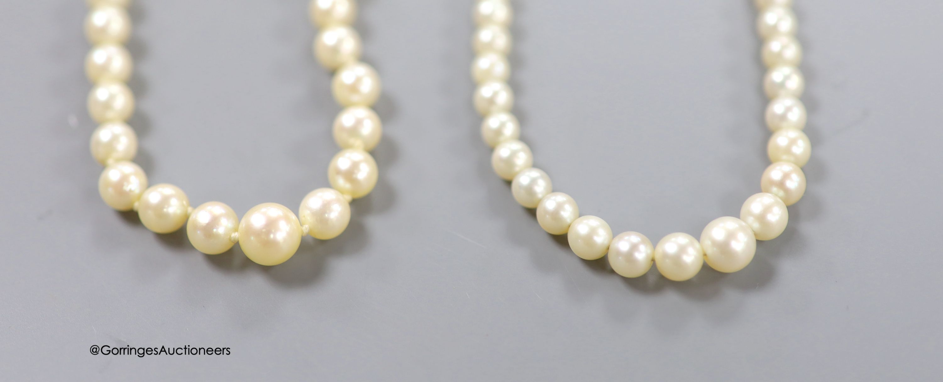 Two single strand graduated cultured pearl necklaces, one with 14k white metal clasp,45cm, the other with 9ct white metal clasp, 40cm.